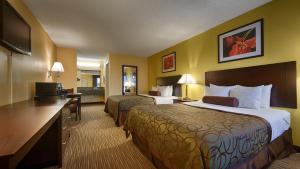 a hotel room with two beds and a television at Days Inn by Wyndham Round Rock in Round Rock
