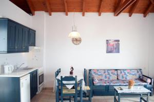 a living room with a couch and a table and a kitchen at Votsalo Apartments in Patitiri