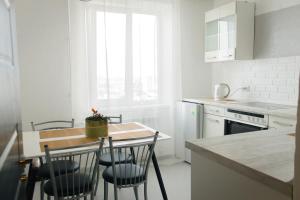 a white kitchen with a table and chairs in it at Sky the Apartment Centre in Tiraspol
