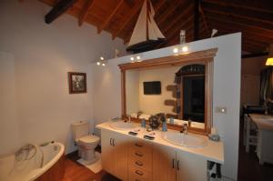 a bathroom with two sinks and a toilet and a mirror at Casa"La Gomera" in Los Silos