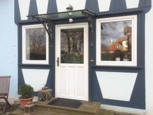 a blue house with a white door and windows at Pension Elise in Wolkramshausen