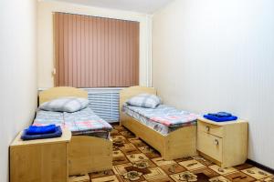 Cette chambre comprend 2 lits jumeaux et une fenêtre. dans l'établissement Apartment TwoPillows on Mayakovskogo 3, à Vorkuta