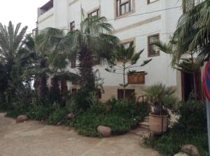 een gebouw met bomen en planten ervoor bij Appartement Taghazout in Taghazout