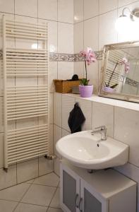 a white bathroom with a sink and a mirror at Pension Elise in Wolkramshausen