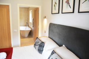 a bedroom with a bed and a bathroom with a tub at Campion Lodge in Chappel