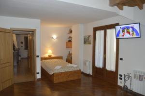 a bedroom with a bed and a tv on a wall at Grande appartamento I Faggi in Abetone