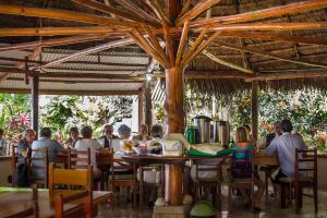 un gruppo di persone seduti a un tavolo in un ristorante di Hotel Rancho Corcovado a Bahía Drake