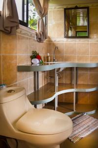 a bathroom with a toilet and a sink at Hotel Rancho Corcovado in Drake