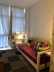 a couch sitting in a living room with a window at Apartamento do Washington in Salvador