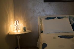 a bedroom with a bed and a lamp on a night stand at Welcome Dimora in Polignano a Mare