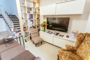 a living room with two chairs and a flat screen tv at Ghand in-Nanna B&B in Mellieħa