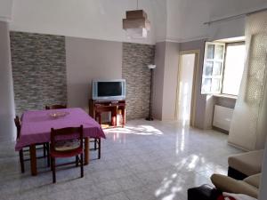 a living room with a table and a tv at Corte dei Giorgi in Vernole
