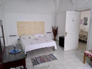a white bedroom with a bed and a table at Corte dei Giorgi in Vernole