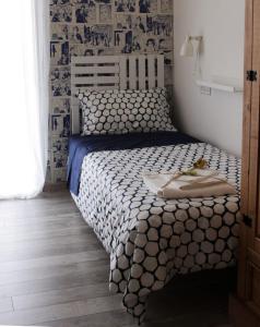 um quarto com uma cama com um edredão preto e branco em Alloggio Lentini em Carlentini