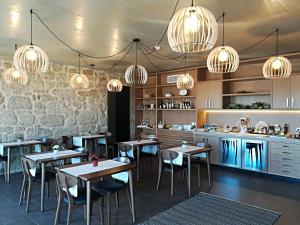 a restaurant with tables and chairs and chandeliers at Carvalhal Redondo - Farm House in Castelo Novo