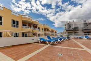 rząd niebieskich leżaków na budynku w obiekcie Ocean Pearl Apartment w mieście Puerto de Santiago
