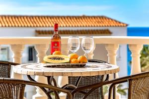 a table with a bottle of wine and two glasses at Ocean Pearl Apartment in Puerto de Santiago