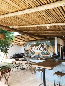 洛斯桑托斯的住宿－Hostal Juan Palitos，一组桌子和椅子,位于木制天花板下