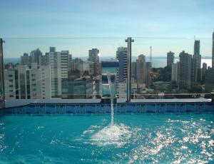 una fuente en el agua con una ciudad en el fondo en SSA001 - Cobertura de luxo para 2 pessoas em Salvador, en Salvador