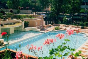 una piscina con flores rosas delante en Hotel Cannes - in pieno centro, en Riccione