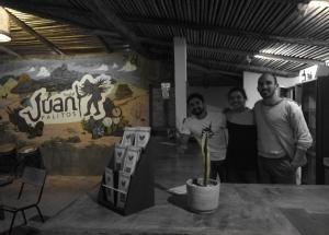 un grupo de tres personas de pie en una habitación con una planta en Hostal Juan Palitos, en Los Santos