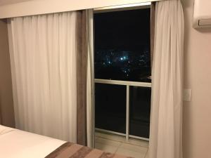 a bedroom with a window with a view of a city at Rio Stay Rio Centro in Rio de Janeiro
