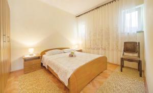 sypialnia z łóżkiem, krzesłem i oknem w obiekcie Apartments Andela w mieście Brseč