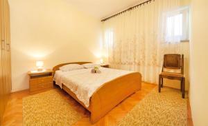 sypialnia z łóżkiem, krzesłem i oknem w obiekcie Apartments Andela w mieście Brseč