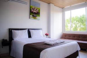 Un dormitorio con una cama grande y una ventana. en Hotel Quinta del Sol, en Arauca