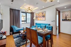 a living room with a table and blue chairs at Paris Deli Danang Beach Hotel in Danang