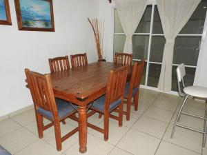 a wooden dining room table with six chairs at Nuevo Vallarta Casa Neptuno in Nuevo Vallarta