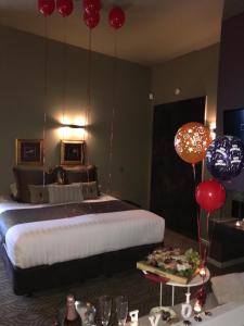 a bedroom with a bed with balloons hanging from the ceiling at Spa Suites at RAVEN in Hepburn Springs