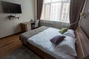 a bedroom with a bed and a large window at MAXX inn in Astana