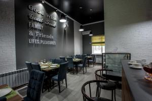 a restaurant with tables and chairs and a sign on the wall at MAXX inn in Astana