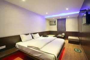 1 dormitorio con 1 cama grande y TV en Hotel Varanasi Palace, en Varanasi