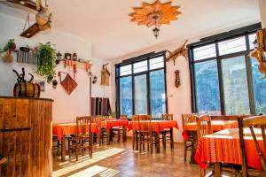 un restaurante con mesas, sillas y ventanas en Guest House Konakat, en Orehovo