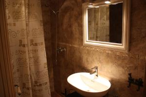 ein Badezimmer mit Waschbecken und Spiegel in der Unterkunft Apartamentos El Jardín del Poeta in Guijo de Granadilla