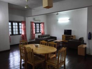 Titi Panjang Apartment Lumut Sitiawan Manjung في لوموت: غرفة معيشة مع طاولة وكراسي وأريكة
