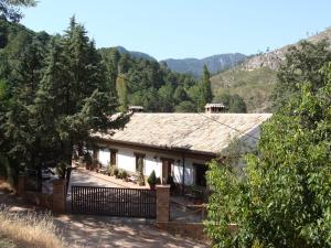 une maison dans les montagnes avec une clôture dans l'établissement Alojamientos Rurales Navahondona, à Arroyo Frío