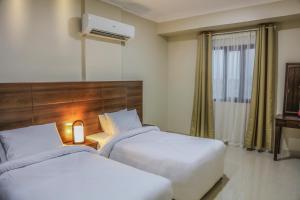 سرير أو أسرّة في غرفة في Barka Hotel Apartment