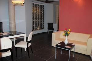 a living room with a couch and a table with a vase of flowers at B&B Via Gallipoli in Alezio