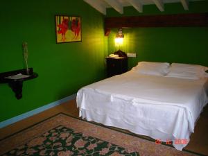 a green bedroom with a bed and a green wall at Casa de Güela in Santillana del Mar