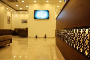 een lobby met een klok aan de muur en een bank bij Barka Hotel Apartment in Samhān