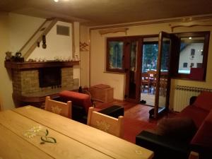 a living room with a table and a fireplace at Holiday Home Jela in Mrkopalj