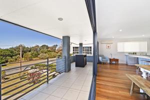 an open kitchen and living room with a view of the ocean at 143 Matthew Flinders Drive, Port Macquarie in Port Macquarie