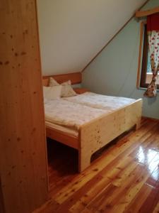 Łóżko w pokoju z drewnianą podłogą w obiekcie Holiday Home Jela w mieście Mrkopalj