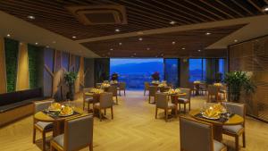 a restaurant with tables and chairs and a large window at Rosaka Nha Trang Hotel in Nha Trang