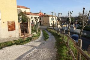 a dirt road next to a fence next to a building at Happy Flat in Riparbella