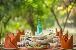 una mesa con platos de comida y tazones de comida en Bandhavgarh Jungle Lodge, en Tāla