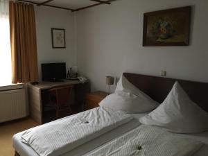 Schlafzimmer mit einem Bett und einem Schreibtisch mit einem Computer in der Unterkunft Paciello Restaurant Hotel in Velbert
